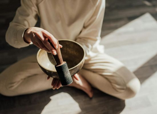 Peaceful person sitting in meditation with soft lighting.