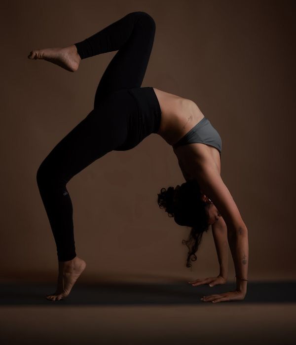 Woman practicing a calm yoga pose in a minimal studio.